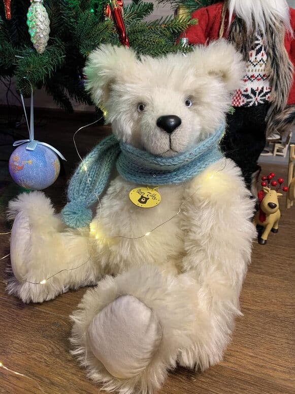 Yuki seated by a Christmas tree in a blue scarf