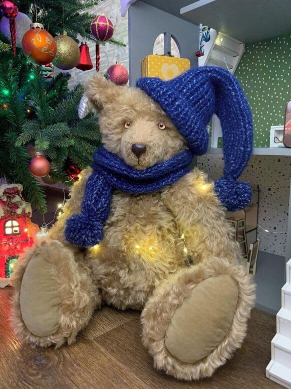 Noel seated in his handmade midnight-blue scarf and hat