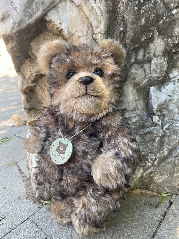Chester, a woodland mohair artist bear, seated outdoors