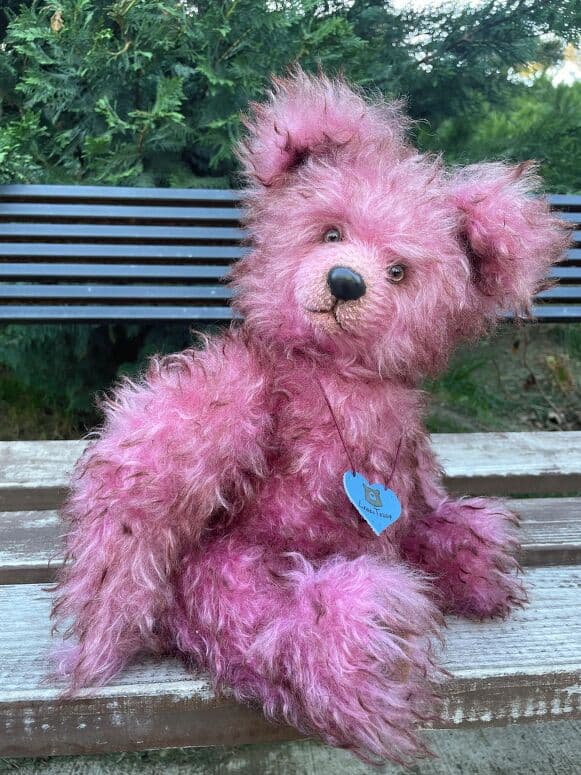 Cassis, a berry-rose mohair artist bear, seated full length